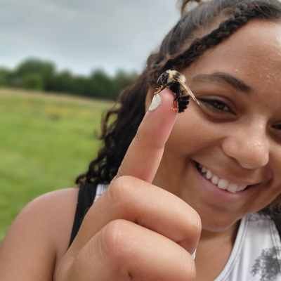 An image of sharron ronnie miller holding a bee